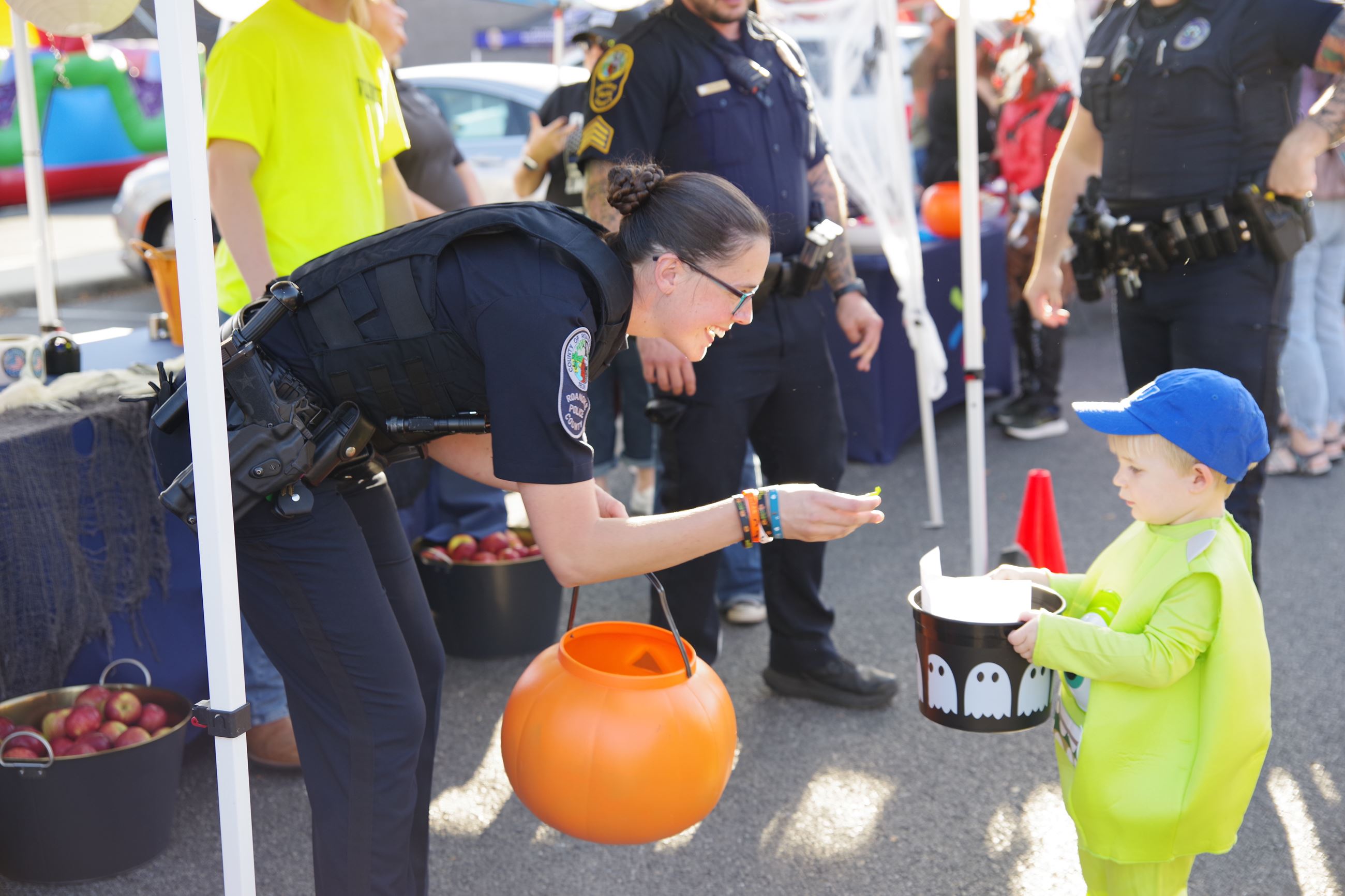 An officer hands a child candy at a Halloween event
